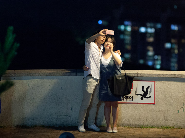 夜景をバックに記念撮影中のカップル