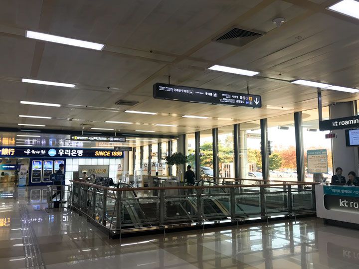 1.到着ゲート(1階)の左前方(写真)、または右前方に見えるエスカレーター(階段)で地下1階へ。 1.到着ゲート(1階)の左前方(写真)、または右前方に見えるエスカレーター(階段)で地下1階へ。