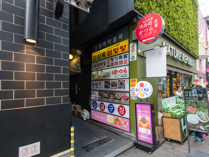 店舗の看板が飾られている路地の入口