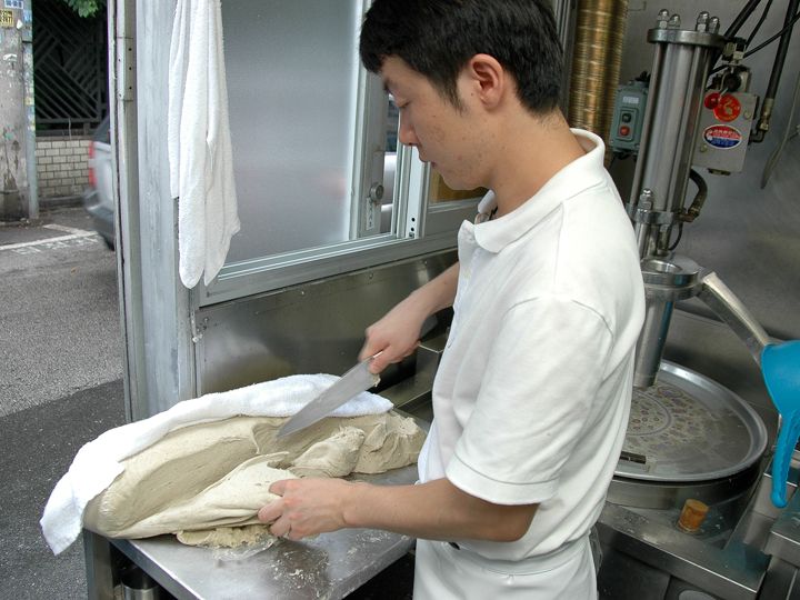 手でこねた塊を機械に入れます