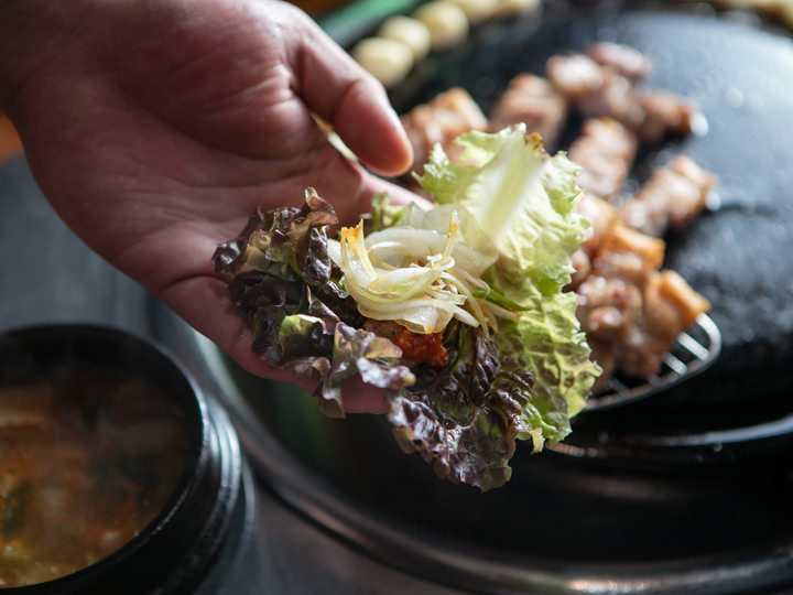 葉野菜にお肉、ネギの和え物やサムジャンをのせて