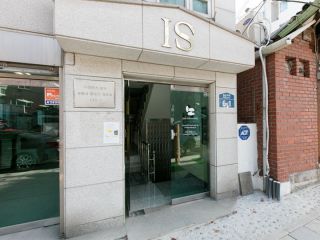 「IS」と書かれたビルの２階に位置