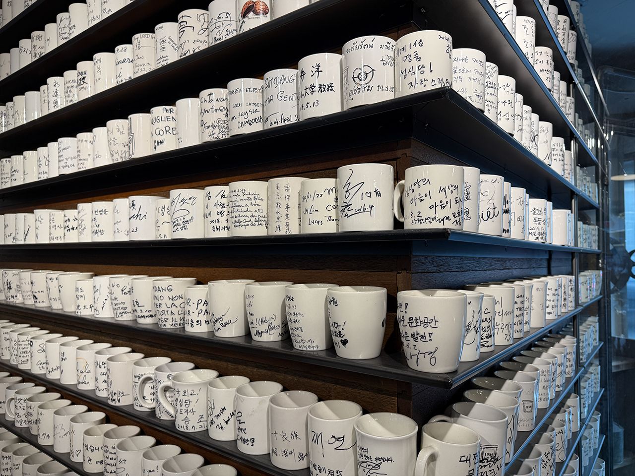 マグカップには、聖心堂を訪問した著名人のサインがズラリ