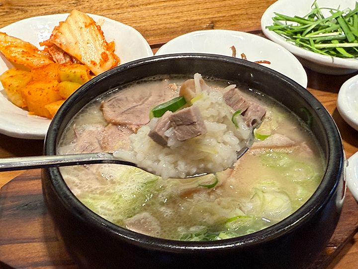 スープの中には豚肉、ご飯、ネギが入っている
