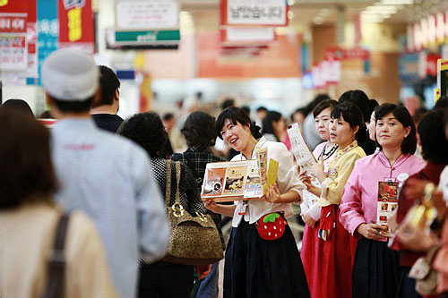 伝統衣装のチマチョゴリ(韓服、ハンボッ)姿で売込みをする店員