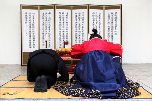 正装姿でお膳に向かってお辞儀