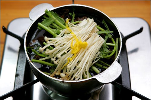 鍋がガスコンロごと登場、火にかけます