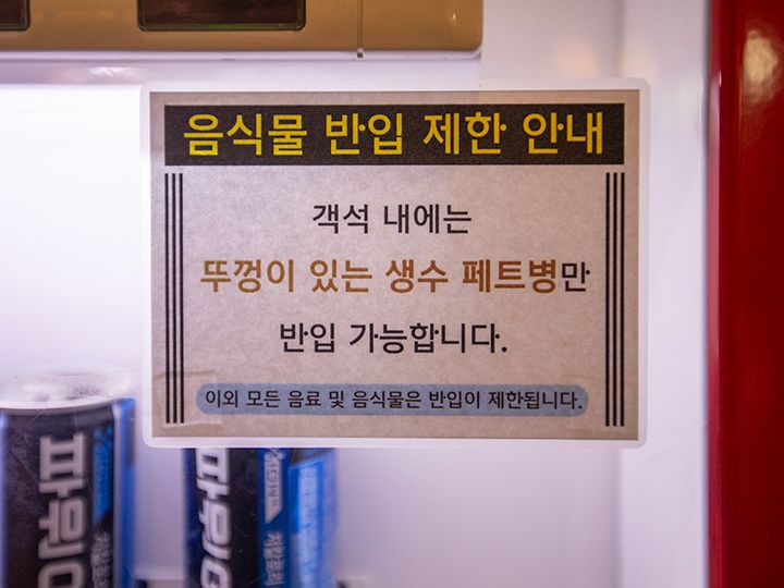 自動販売機に貼られた「ミネラルウォーターのみ持ち込み可」という案内