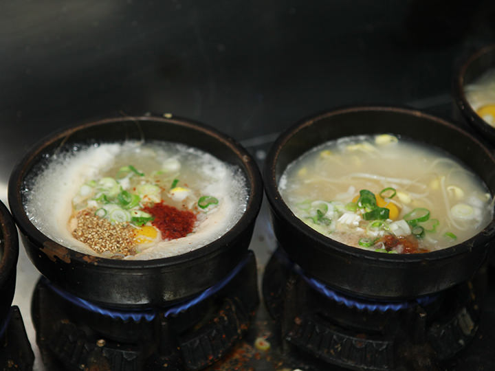 お客さんでにぎわう食事時の厨房では、一度に10個近くのコンナムルクッパを火にかけることも。スタッフは息つく暇もなくコンナムルクッパを作っています。