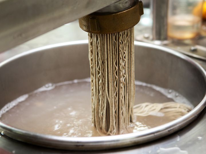 押し出した麺を、沸騰したお湯に投入して茹でます。