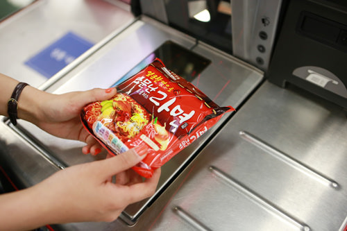 2.商品のバーコードを機械にスキャン。スキャンし終わった商品を左の台に置きます。