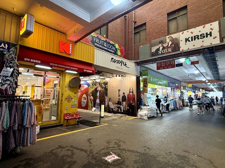 市場の通りの黄色いファッション店「コダック」が目印